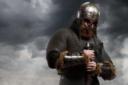 Under dark, atmospheric skies, a viking clutches a sword